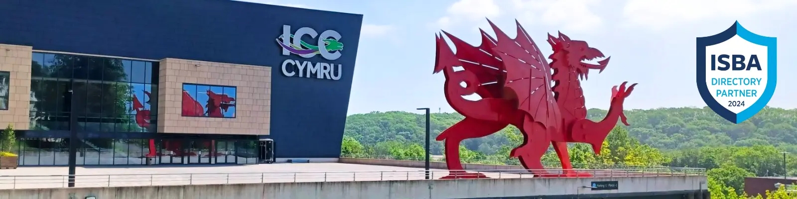 The International Convention Centre in Newport Wales, pictured against a blue sky with a red dragon to the right of the building, with an 'ISBA directory partner 2024' crest in the top right corner