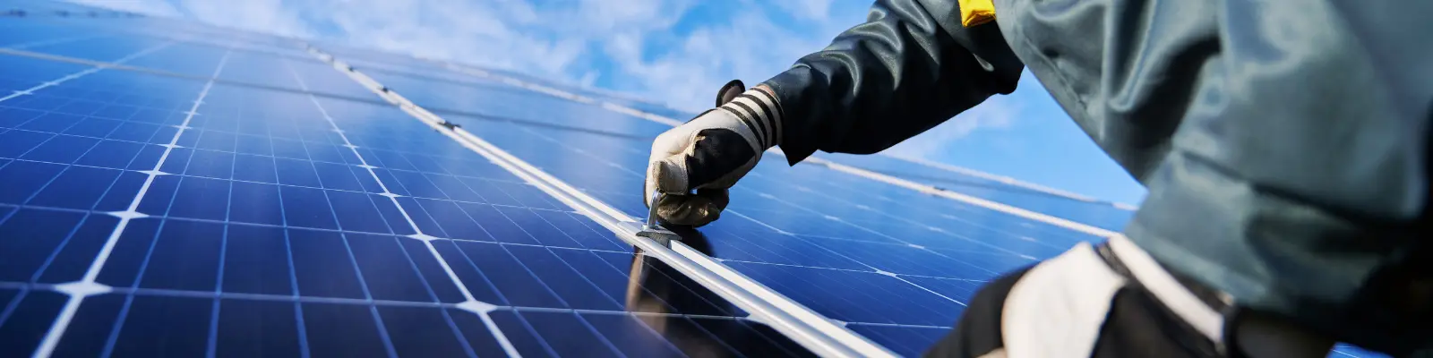 A close up of a pair of gloved hands installing a solar panel